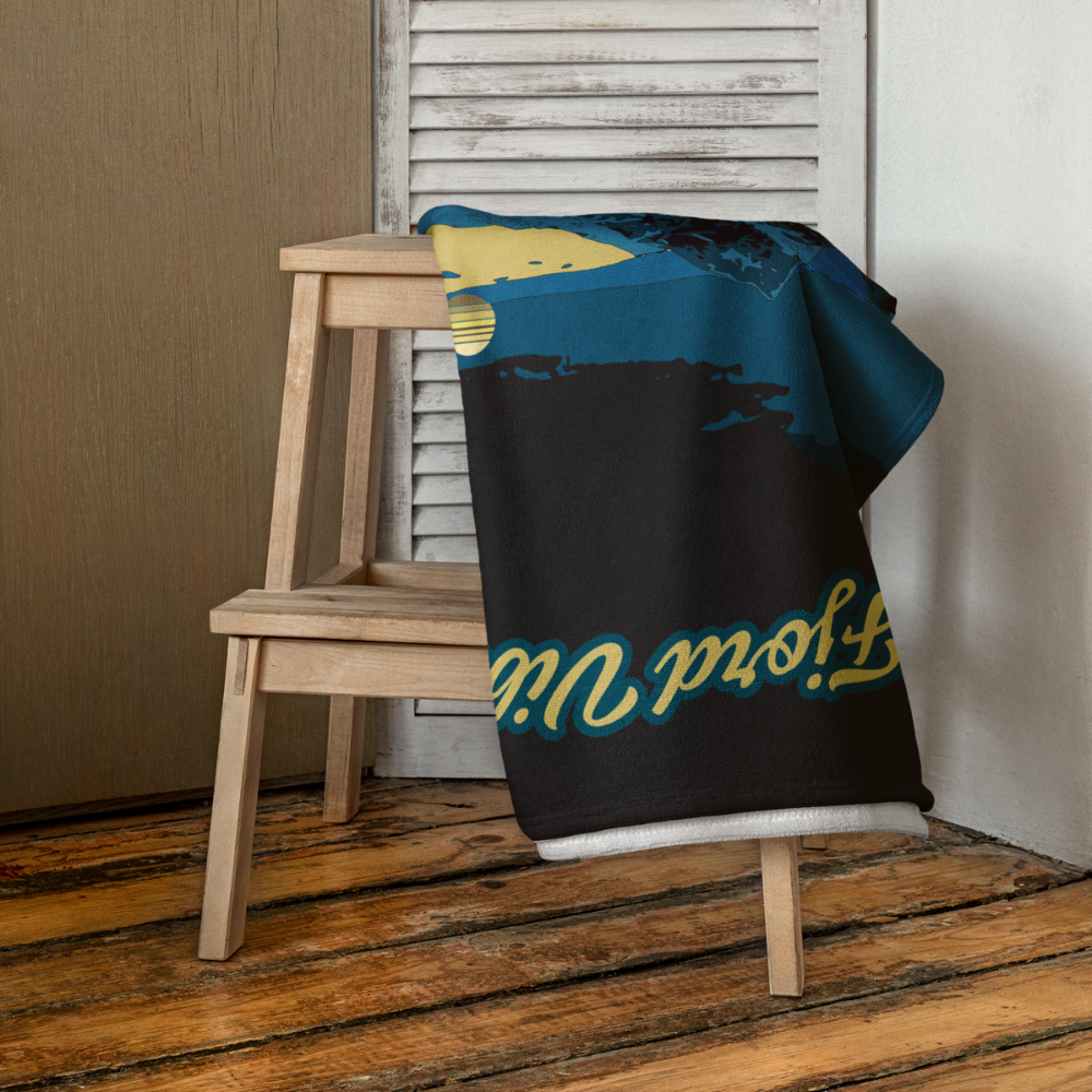 Fjordvibes_badehanduk_liggende_over_en_stol_gul_og_bla